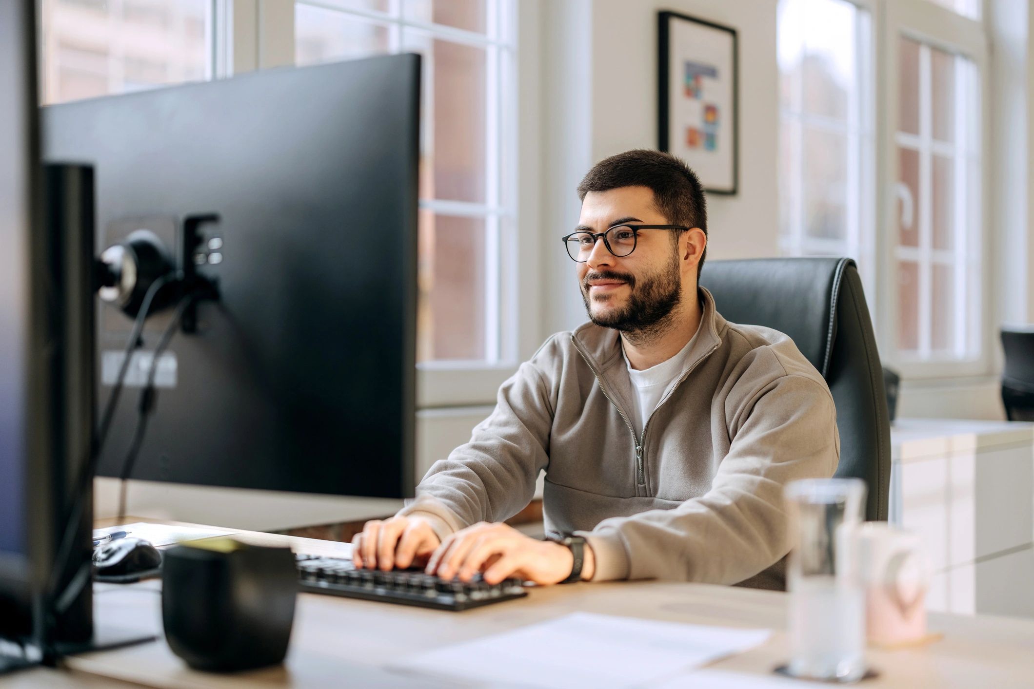 Professional working at a desktop computer in a modern office