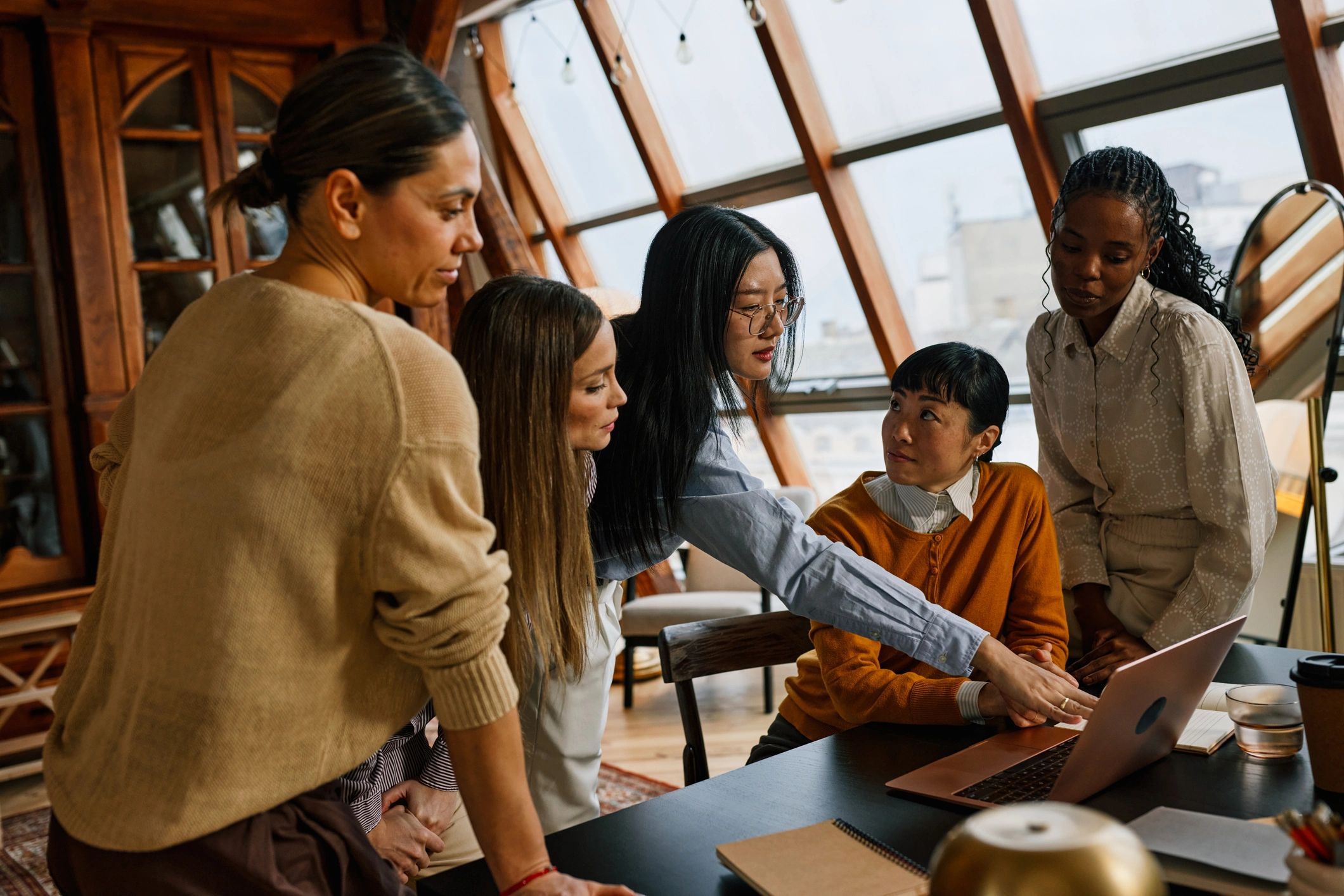 Team collaborating around a laptop in a creative office